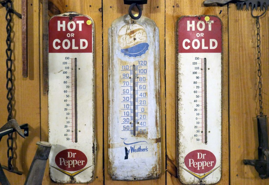 3 old thermometers hanging on a wall