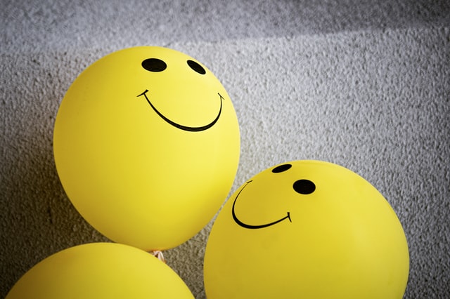 Two yellow balloons with smiley faces.